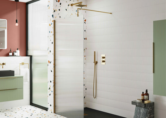 Brushed brass shower with brushed brass shower screen, wall mounted basin vanity unit and white Kik cat wall tiles