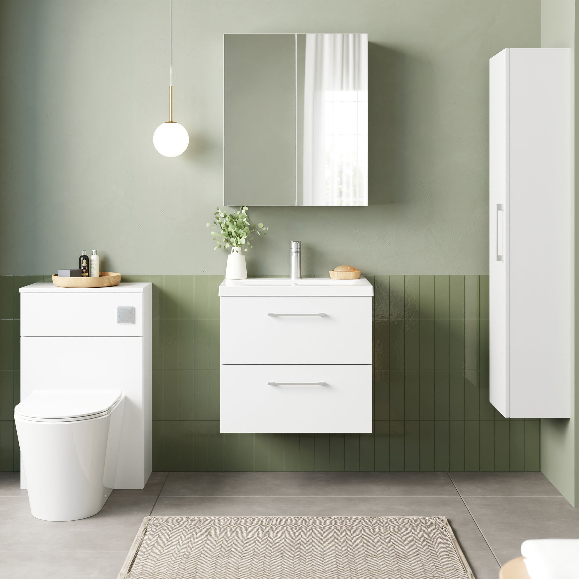 Bathroom setup with white vanity, toilet, and cabinet against a green tiled wall.