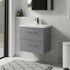 Bathroom setup with a gray vanity unit, white sink, and black cabinet.