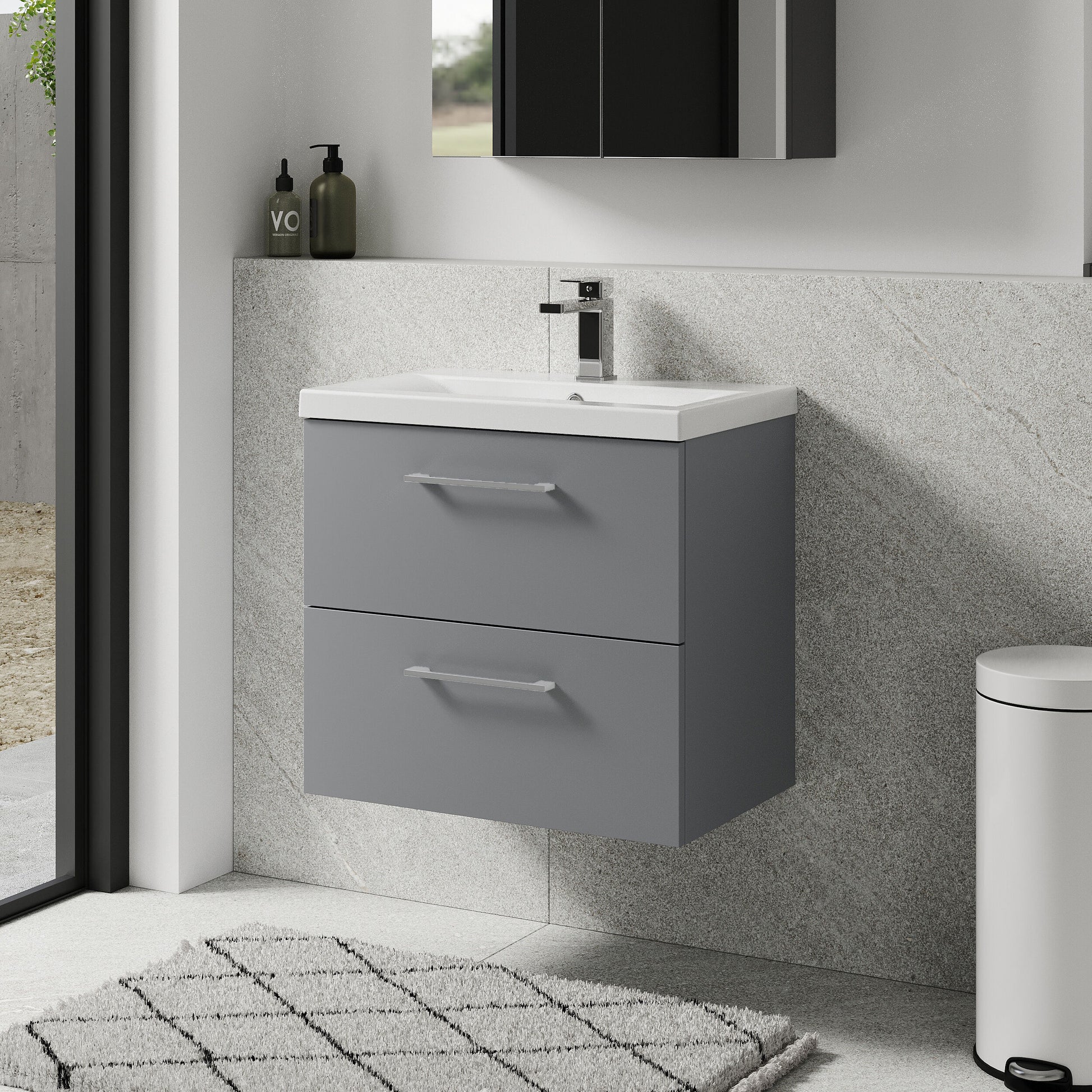 Bathroom setup with a gray vanity unit, white sink, and black cabinet.