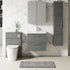 Bathroom setup with gray vanity, toilet, and cabinets against a marble wall.