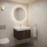 Modern bathroom with a round illuminated mirror, sink, and towel.