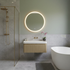 Modern bathroom with a round illuminated mirror, oak fluted floating vanity unit sink, and bathtub.