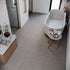 Modern bathroom with a freestanding bathtub, marble countertop, and small table.