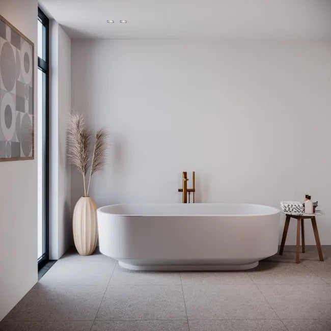 Modern bathroom with a freestanding bathtub, decorative vase, and small table.