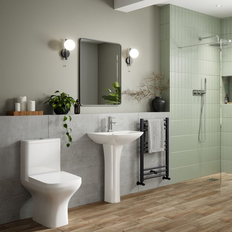 Modern bathroom with toilet, sink, and shower area.