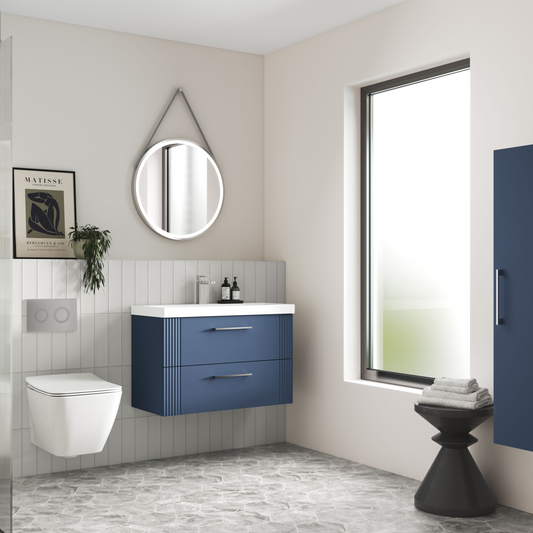 Modern bathroom with blue vanity, white toilet, and large window.