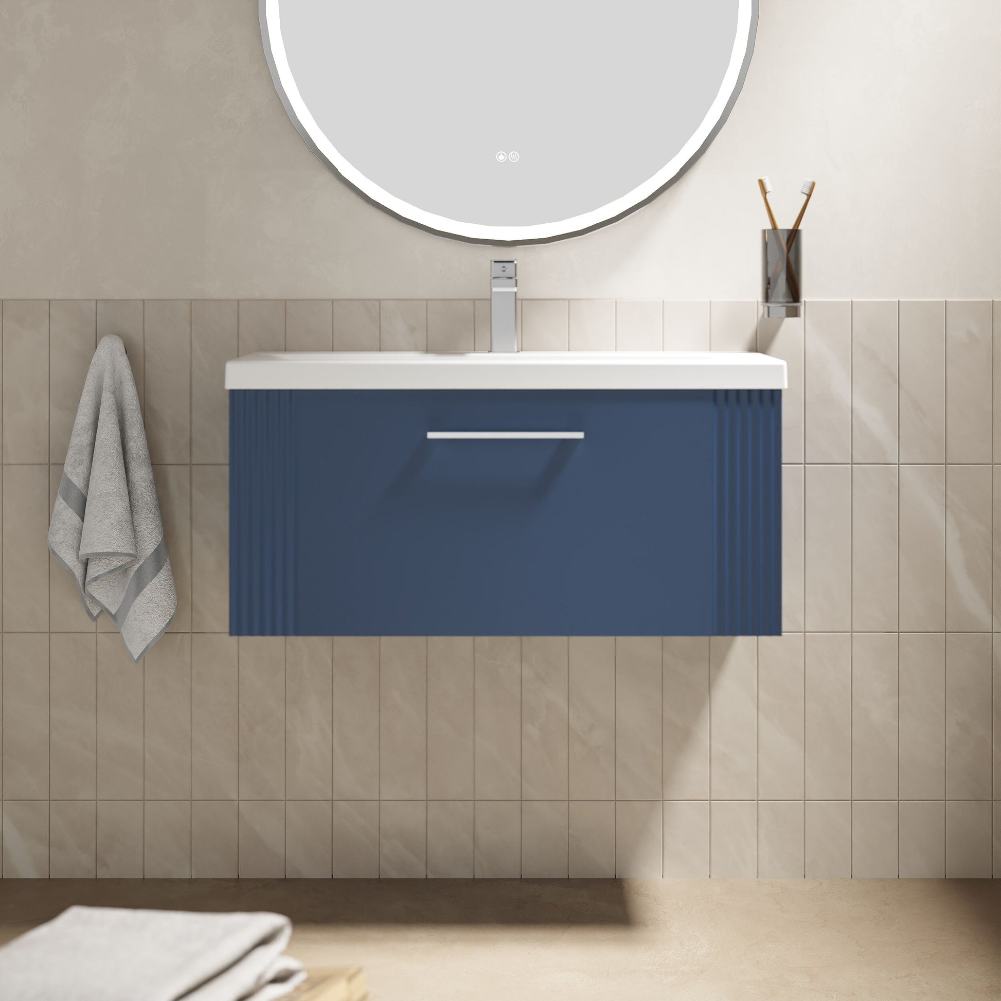 Bathroom vanity with blue cabinet, white countertop, and round mirror on beige tiled wall.