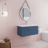 Bathroom with blue vanity, round mirror, and pink wall