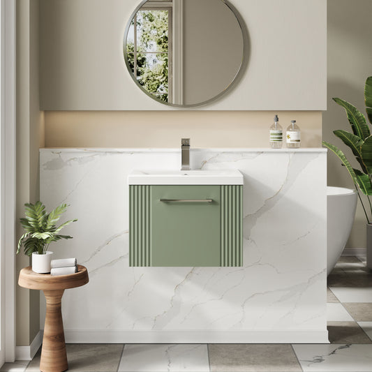 Bathroom interior with a green vanity unit, round mirror, and decorative elements.