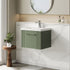 Bathroom with green vanity unit, white countertop, and round mirror.
