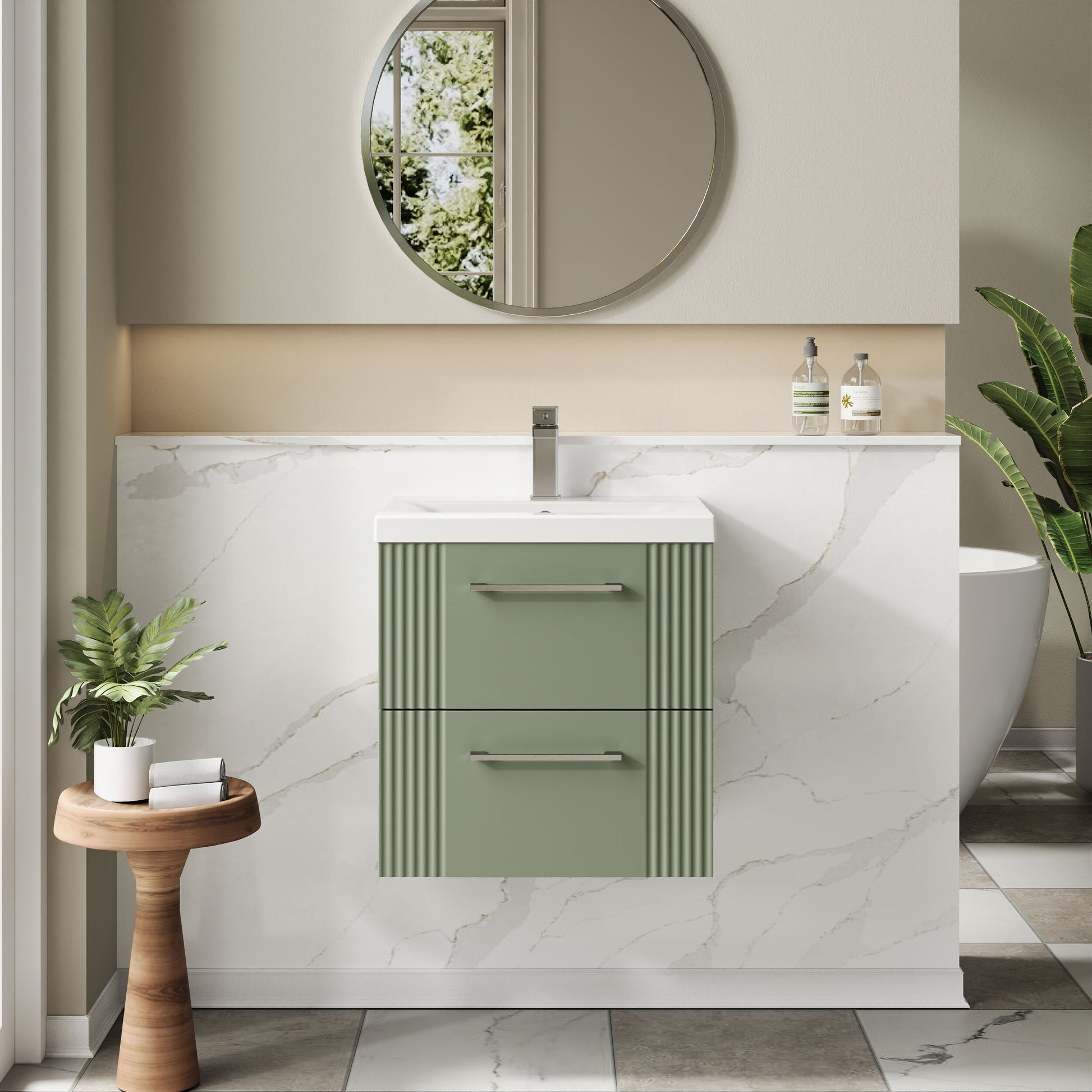 Bathroom with a green vanity unit, round mirror, and potted plants.