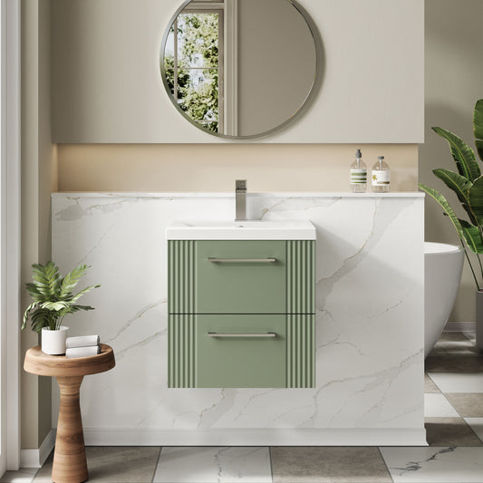Bathroom with a green vanity unit, round mirror, and potted plants.