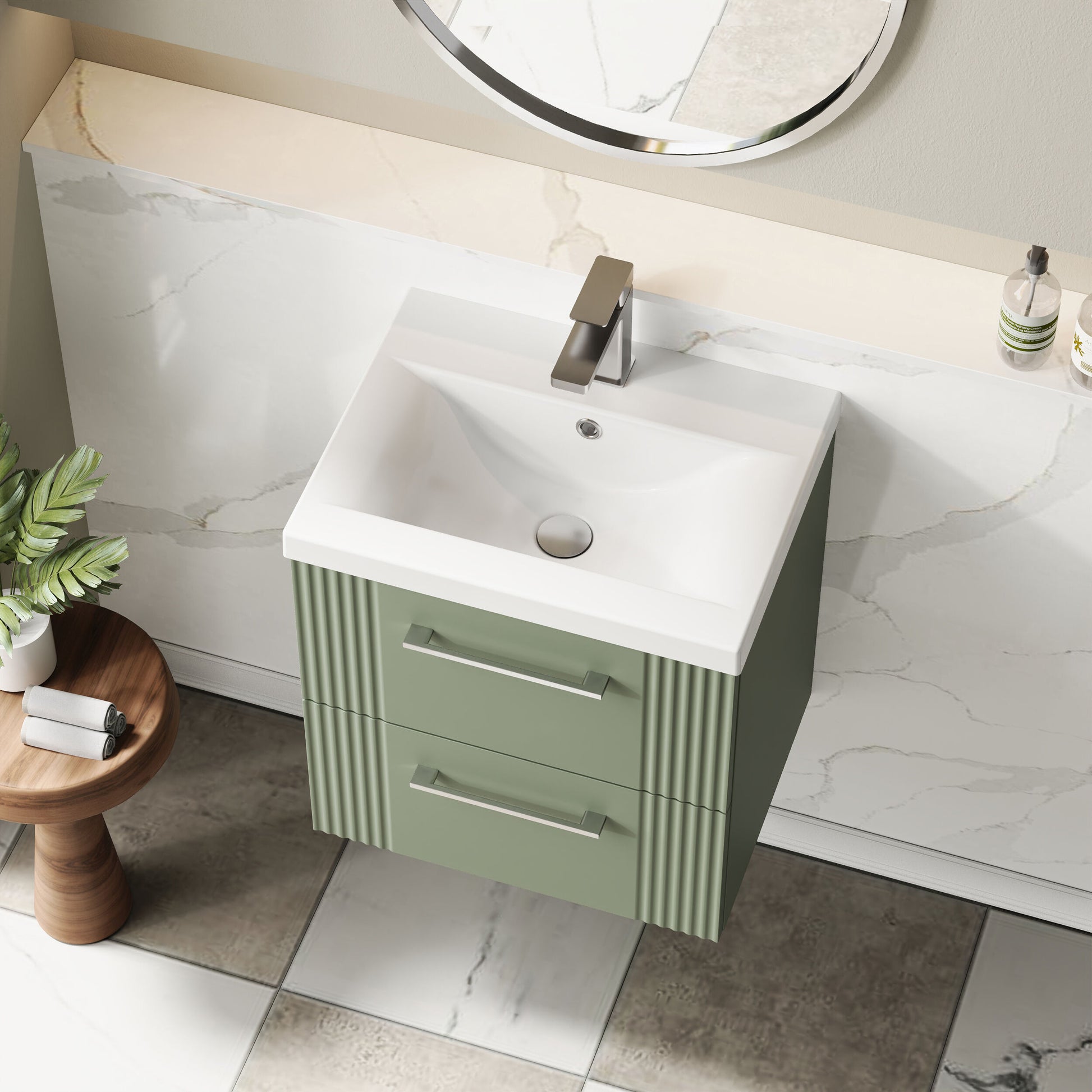 Bathroom vanity with green cabinet, white sink, and round mirror.