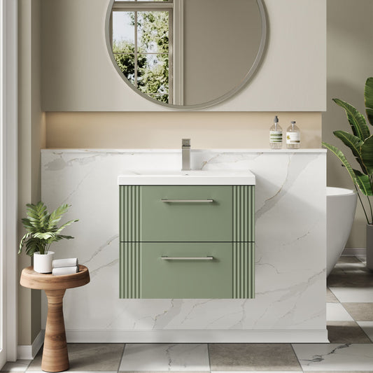 Bathroom vanity with green cabinet, white countertop, and round mirror.