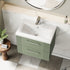 Bathroom vanity with white sink and green base cabinet, featuring a round mirror above.
