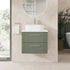 Bathroom vanity with green cabinet and white countertop in a modern bathroom setting.