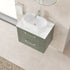 Bathroom vanity with white countertop and green base cabinet.