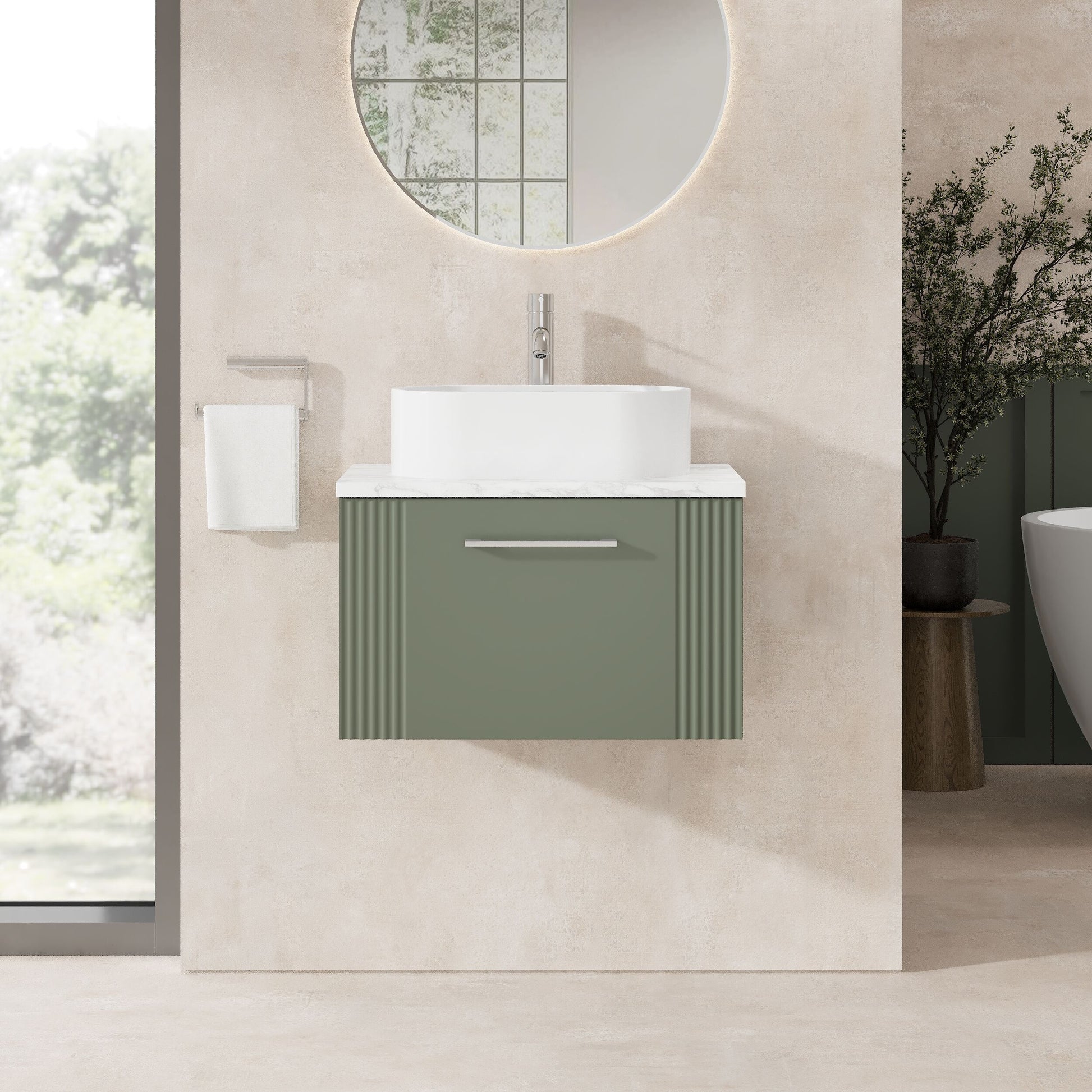 Modern bathroom with a green vanity unit, white sink, and round mirror.