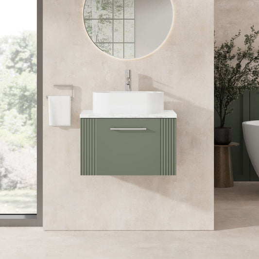Modern bathroom with a green vanity unit, white sink, and round mirror.