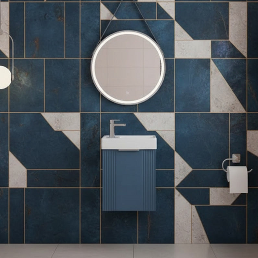 Bathroom with blue and gray tiled wall, round mirror, and blue wall hung basin unit.