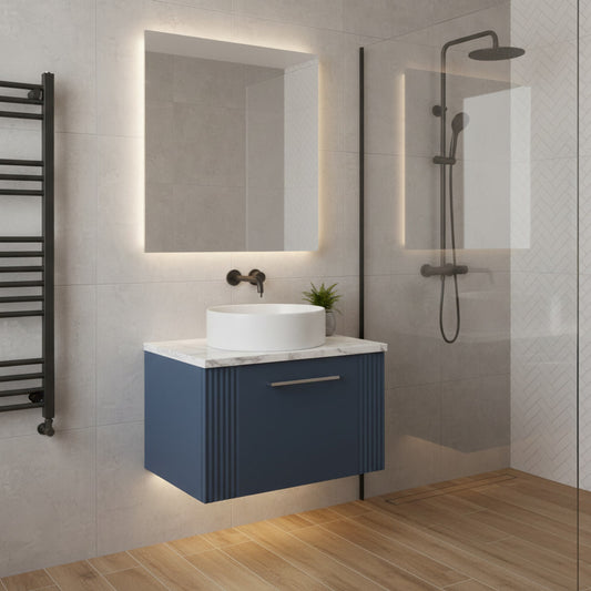 Modern bathroom with blue vanity, white sink, and shower area.