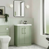 Modern bathroom with green vanity unit, white toilet, and large window.