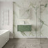 Modern bathroom with green marble wall, sink, and glass shower enclosure.