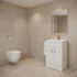 Modern bathroom with beige tiled walls, a white toilet, and a white vanity unit with mirror.