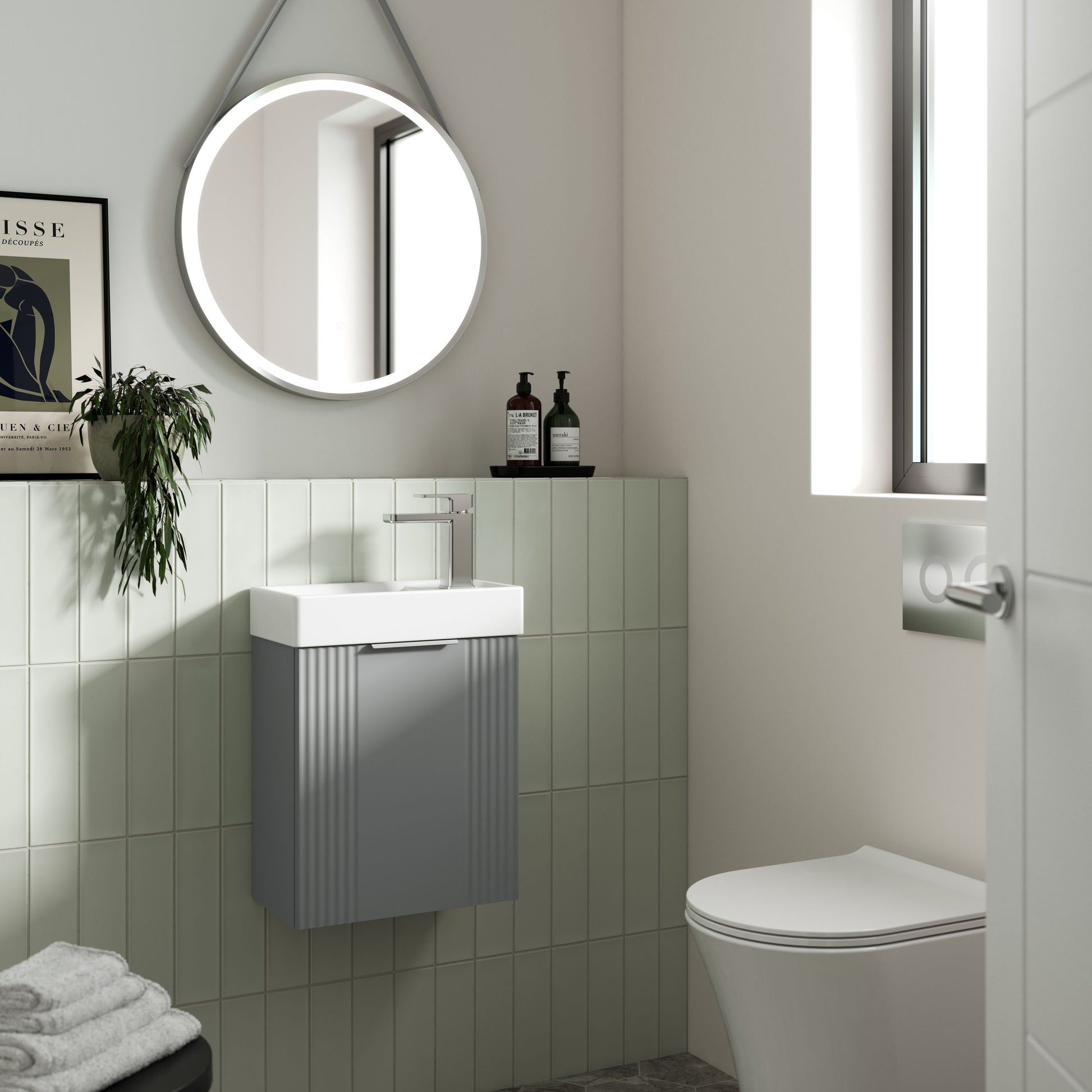 Modern bathroom with a round mirror, sink, and toilet.