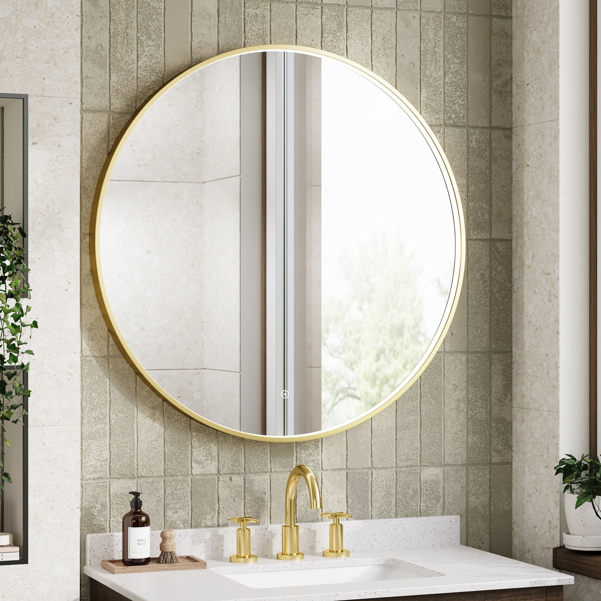 Round gold-framed mirror above a sink with gold fixtures in a bathroom setting.