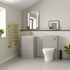 Modern bathroom with gray vanity, toilet, and decorative elements.