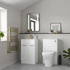 Modern bathroom with white vanity, toilet, and gold towel rack.
