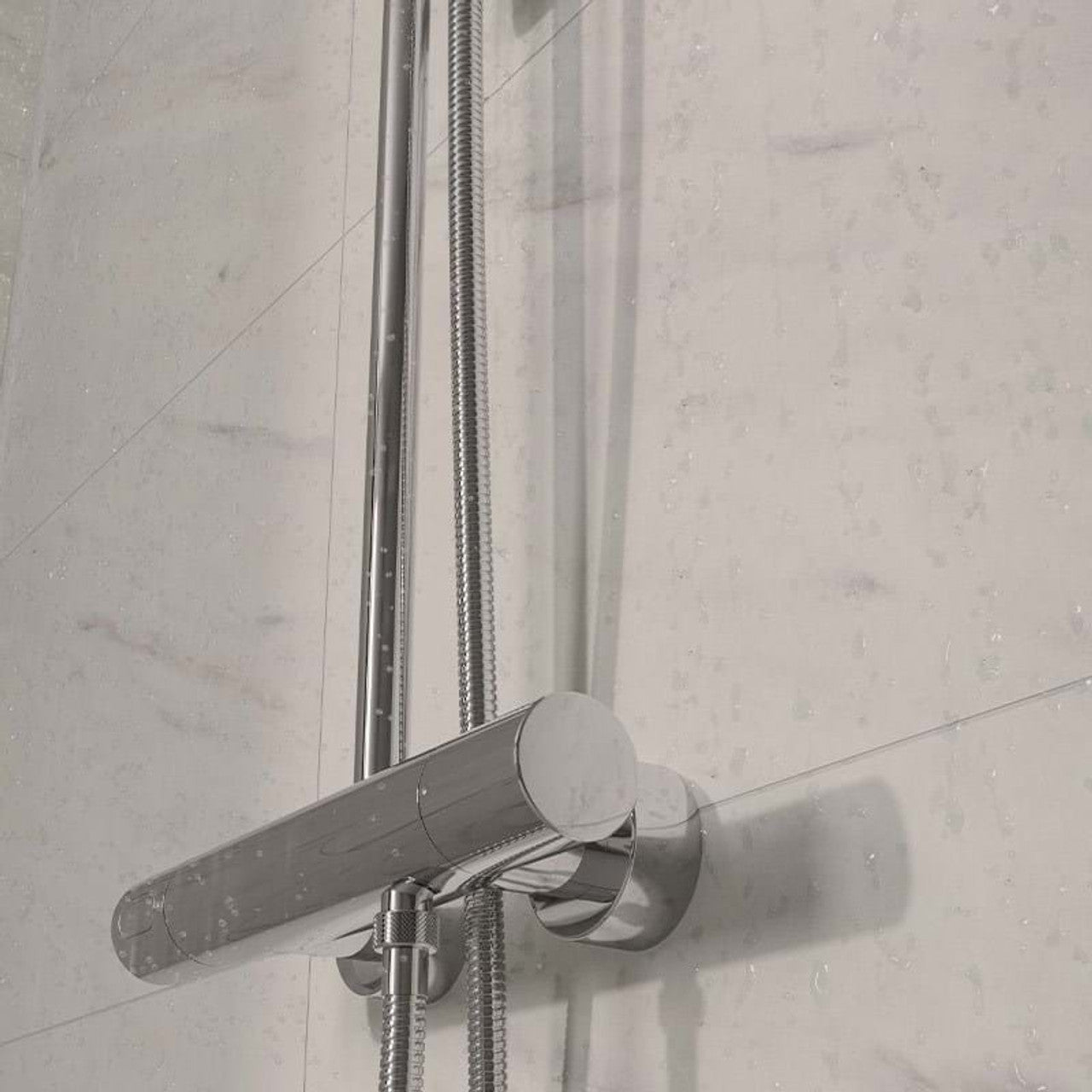 Shower head with hose against a tiled wall Multipanel_Levanto_Marble_Tile_Effect_Wet_Wall_Shower_Panel_bathroom