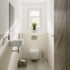 Modern bathroom with Multipanel Riven Marble Classic Wet Wall Shower Panel toilet, sink, and window