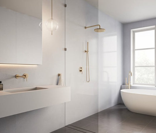 Modern bathroom with white tiles, a freestanding bathtub, and gold fixtures.
