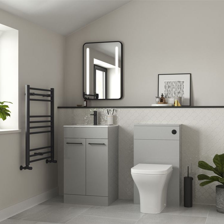 Modern bathroom with gray vanity, toilet, and decorative elements.