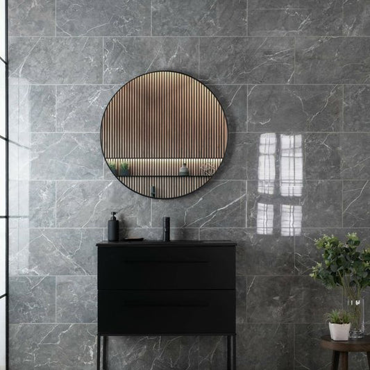 Bathroom with dark grey marble tiles, a round wooden-framed mirror, and a black vanity.