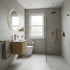 Modern bathroom with gray tiles, wooden vanity, and glass shower enclosure.