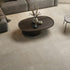 Wooden coffee table with decorative items on a beige stone tiled floor