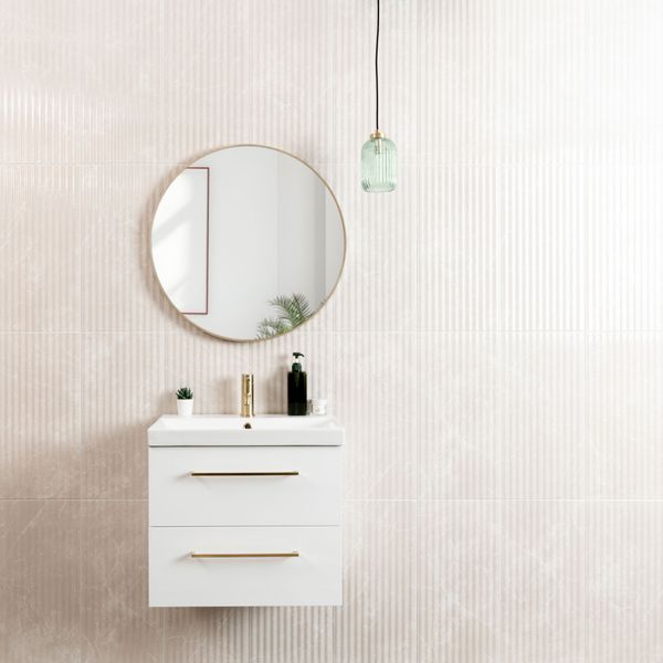 Bathroom vanity with round mirror and hanging light fixture on a fluted wall tiles.