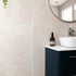 Bathroom with fluted marble tiled wall, sink, and decorative bottle.