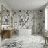 Modern bathroom with marble walls and floor, fluted freestanding bathtub, and gold fixtures.