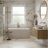 Modern bathroom with marble walls, freestanding bathtub, and wooden vanity.