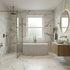 Modern bathroom with marble walls, a fluted freestanding bathtub, and a window.