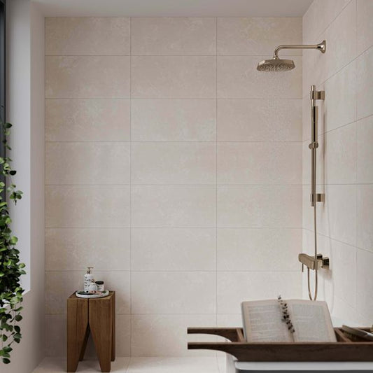 Modern bathroom with warm white tiled walls, shower head, and wooden stool.
