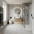 Modern bathroom with gray tiles, wooden vanity, and glass shower enclosure.