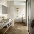 A modern bathroom with white walls and floor featuring stone effect tiles. The tiles are rectangular with a matte finish, and the image shows both installed on the wall and floor.