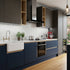 Modern kitchen with dark blue cabinets, white tiles, and stainless steel appliances.