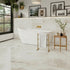 Modern bathroom with a freestanding bathtub, gold towel rack, and decorative elements.